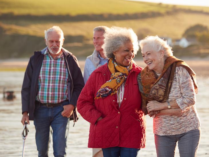 Twee oudere stellen wandelen in een herfstlandschap