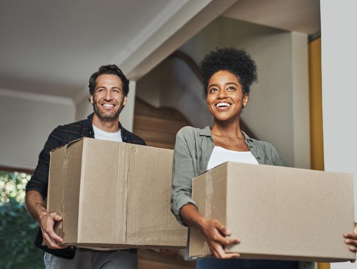 Een jong stel met verhuisdozen in hun nieuwe huis.