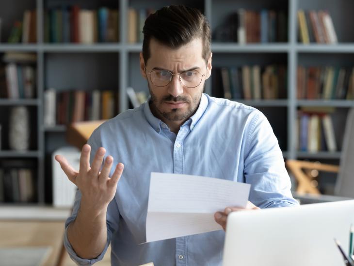 Een man kijkt verbijsterd naar de nieuwe WOZ-waarde van zijn huis