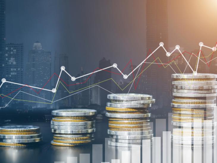 Vier stapeltjes euromunten met een grillige grafief op de achtergrond.