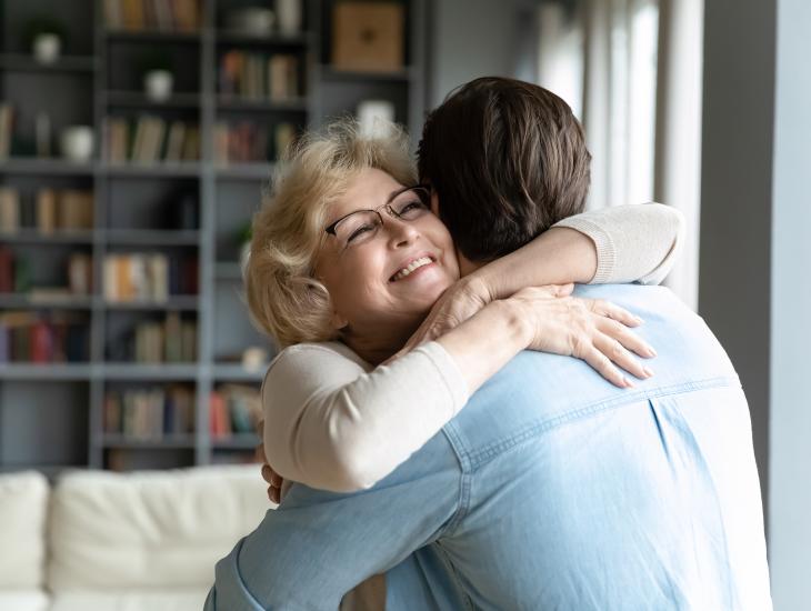Een dankbare zoon omhelst zijn moeder.