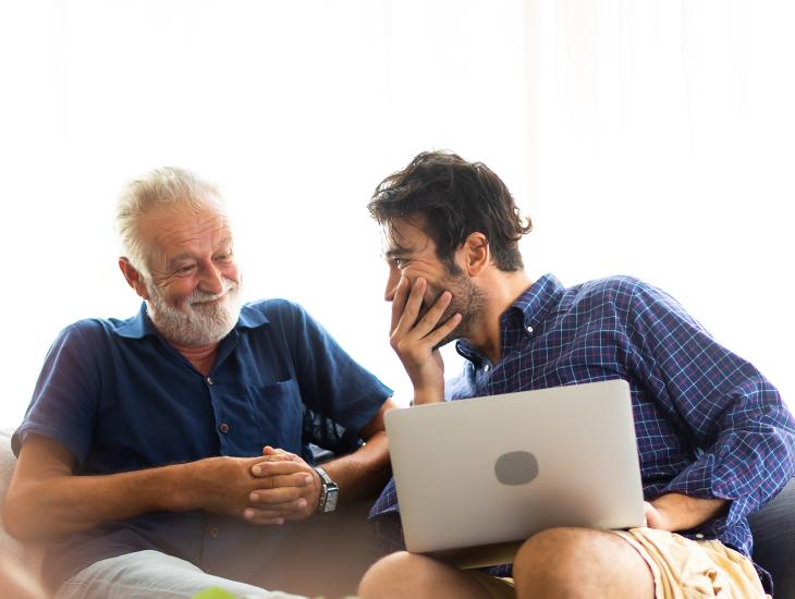 Een zoon zit naast zijn vader op de bank en is overweldigd van blijdschap.