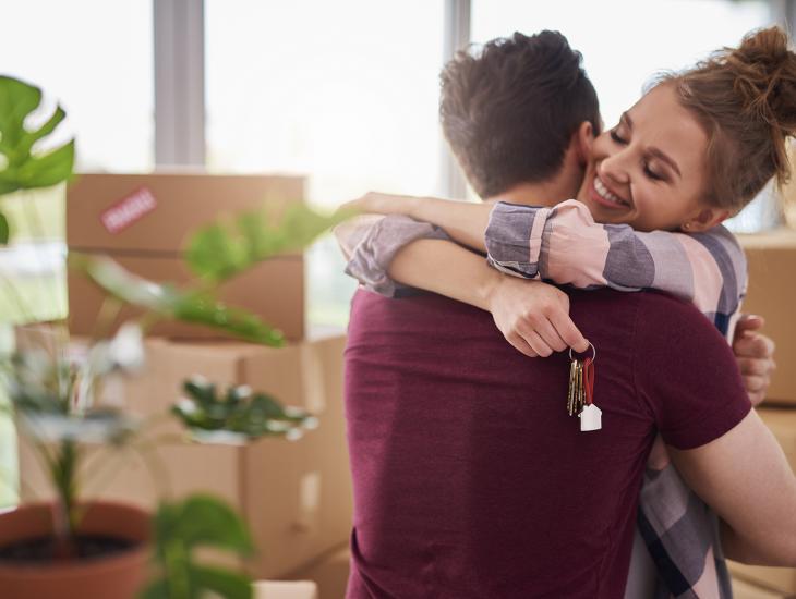 Jong stel omhelst elkaar in hun nieuwe huis