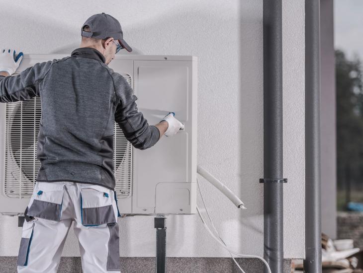 Een monteur installeert een warmtepomp