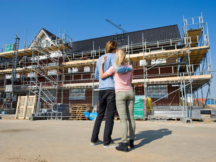 Jong stel bekijkt huis in aanbouw