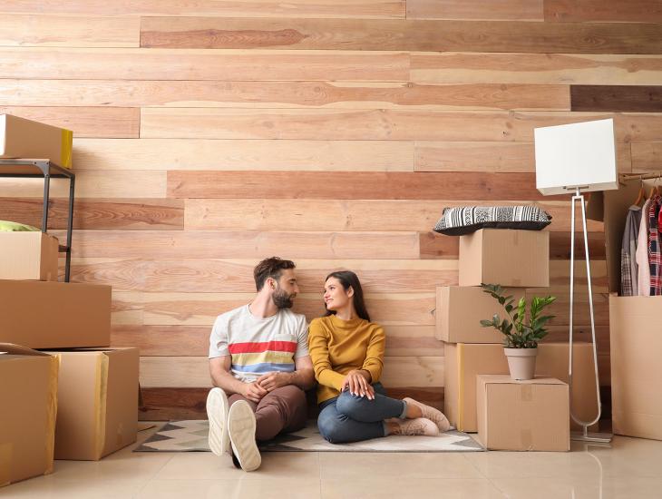 Jong stel zit tussen de verhuisdozen