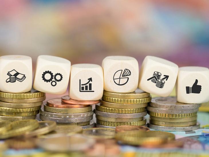 Stapeltje geld met daarop dobbelstenen 