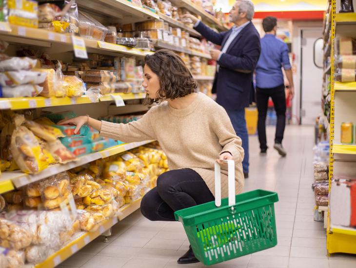 Vrouw zit op haar hurken in de supermarkt