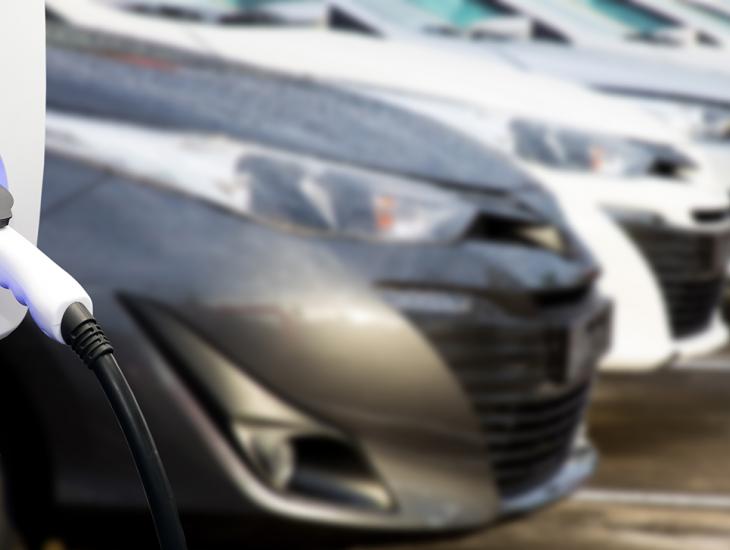 Laadpaal met elektrische auto's op de achtergrond