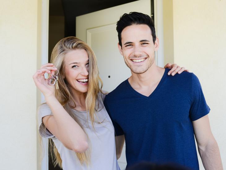 Jong stel voor de deur van hun nieuwe huis