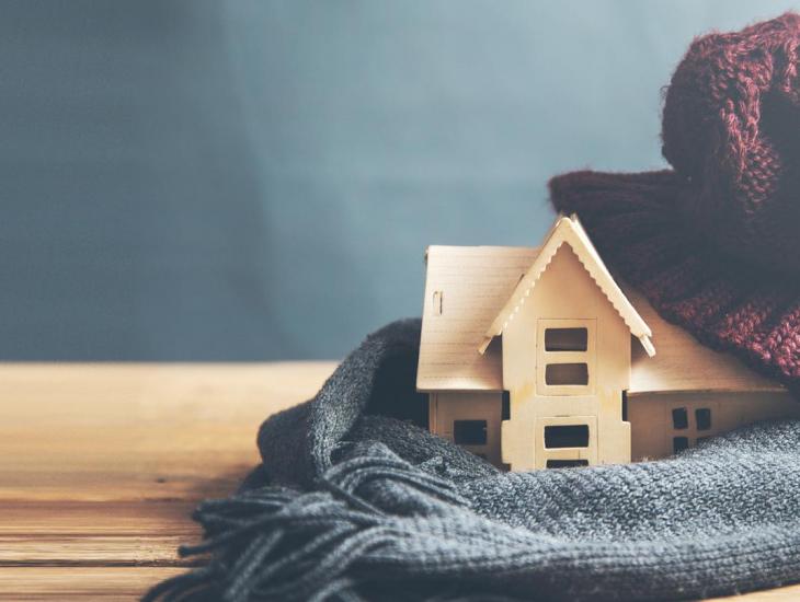 Houten huisje met een sjaal om en een muts op