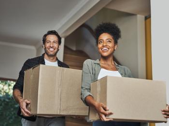 Een jong stel met verhuisdozen in hun nieuwe huis.