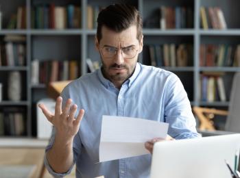 Een man kijkt verbijsterd naar de nieuwe WOZ-waarde van zijn huis