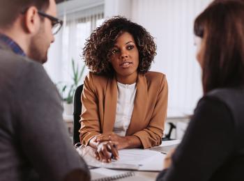 Een stel zit aan tafel bij een financieel adviseur