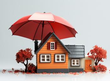 Een modelhuisje dat onder een paraplu staat.