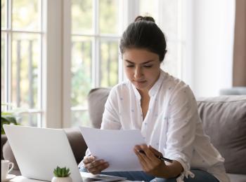 Een jonge vrouw bestudeert het rentevoorstel van haar bank.