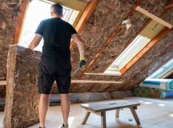 Een man is zijn dak aan het isoleren