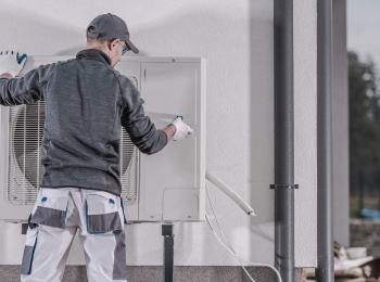 Een monteur installeert een warmtepomp