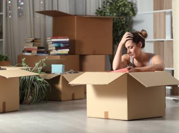 Verdrietige vrouw pakt verhuisdozen in