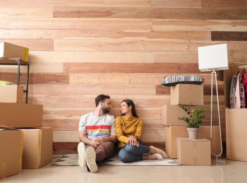 Jong stel zit tussen de verhuisdozen