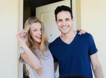 Jong stel voor de deur van hun nieuwe huis