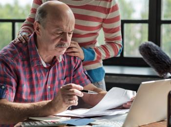 Een man doet de huishoudboekhouding aan tafel